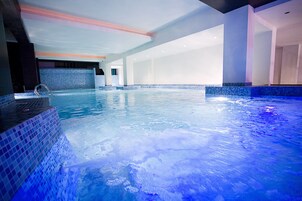 Una piscina cubierta, tumbonas