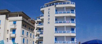 A multi-story hotel with balconies and a clear sky.