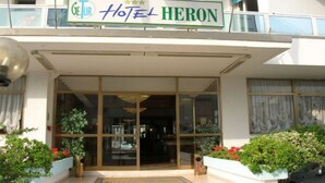 A hotel entrance with a sign reading "Getur Hotel HERON".