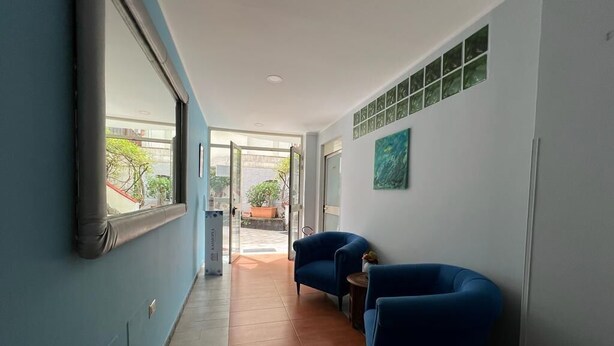 A hallway with blue walls, a window, and two blue armchairs. - Kassiopea Aparthotel (Giardini Naxos)