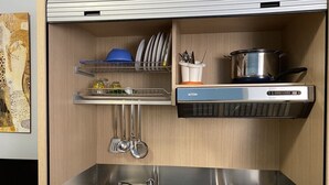 A compact kitchen with a sink, stove, and utensil holder. - Kassiopea Aparthotel (Giardini Naxos)