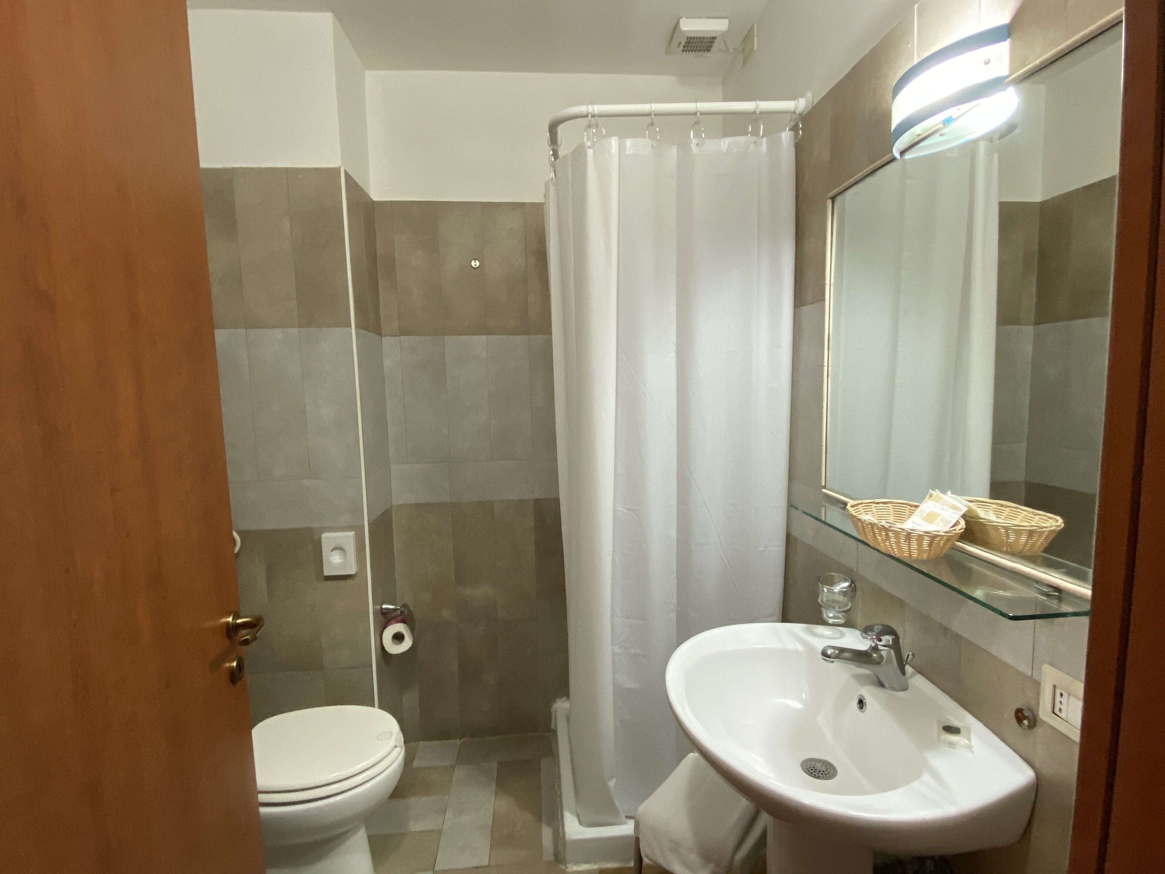 Une salle de bain avec des toilettes, une douche et un lavabo.