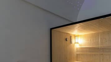 A modern room with a wooden sauna, a reclining chair, and a ceiling with star projections.