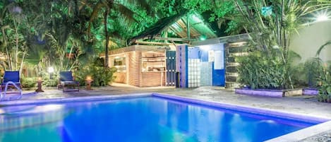 Una piscina al aire libre, sillones reclinables de piscina