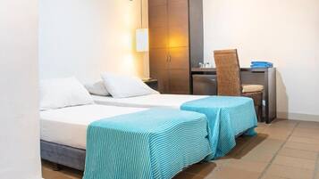Une chambre d’hôtel avec deux lits, un bureau, une chaise et une armoire.