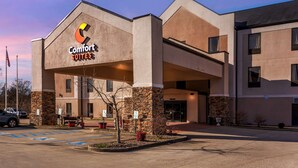 A Comfort Suites hotel with a modern design, featuring a prominent entrance and a parking lot. - Comfort Suites South Point - Huntington (South Point)