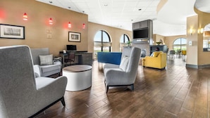 Un espacio habitable amplio con mobiliario moderno, una zona de cocina y ventanas grandes.