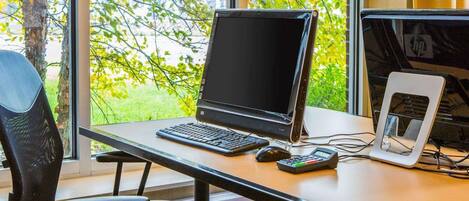 Um espaço de trabalho com um laptop, teclado, rato e uma calculadora sobre uma mesa.