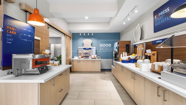 Una cocina moderna con barra para desayunos, mostrador de panadería y una variedad de cereales.