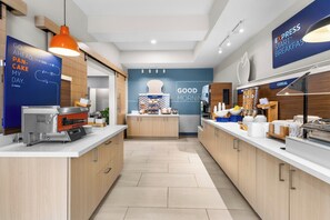 A modern kitchen with a breakfast bar, a bakery counter, and a cereal display. - Holiday Inn Express Hotel & Suites Van Wert by IHG (Van Wert)
