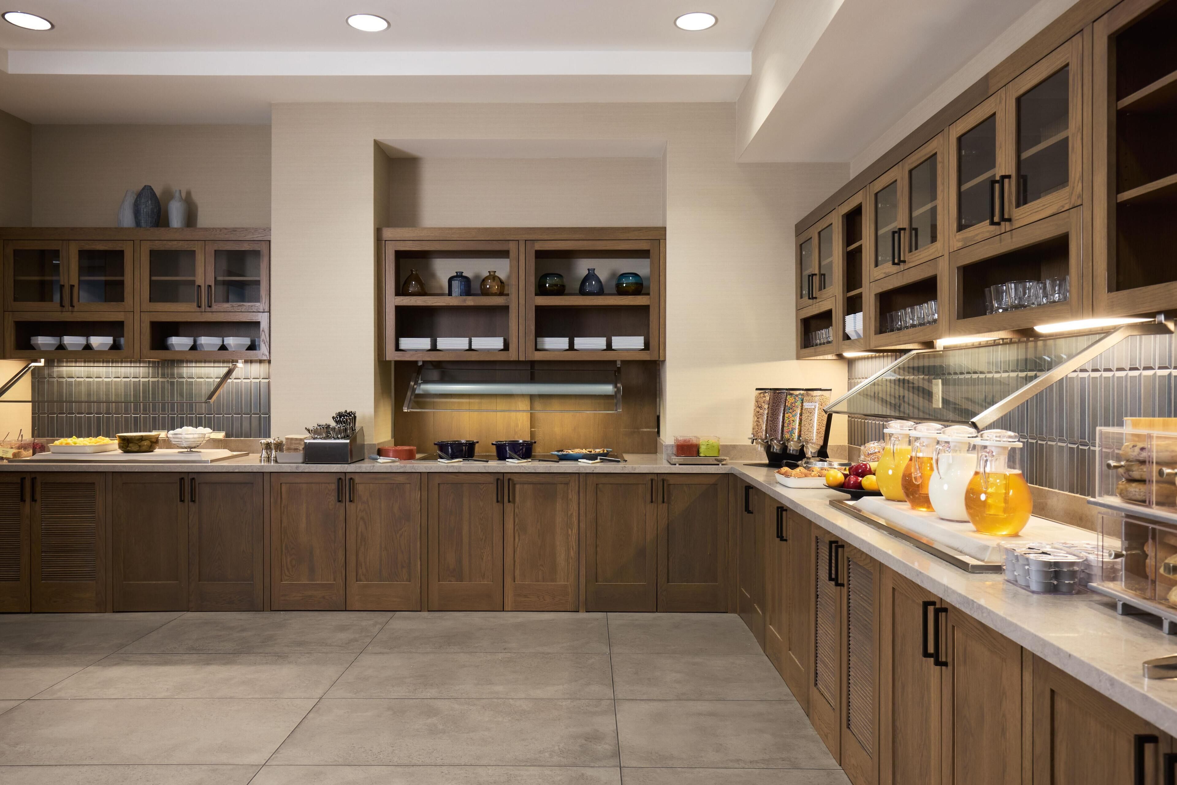 A modern kitchen with wooden cabinets, a central island, and a breakfast bar.