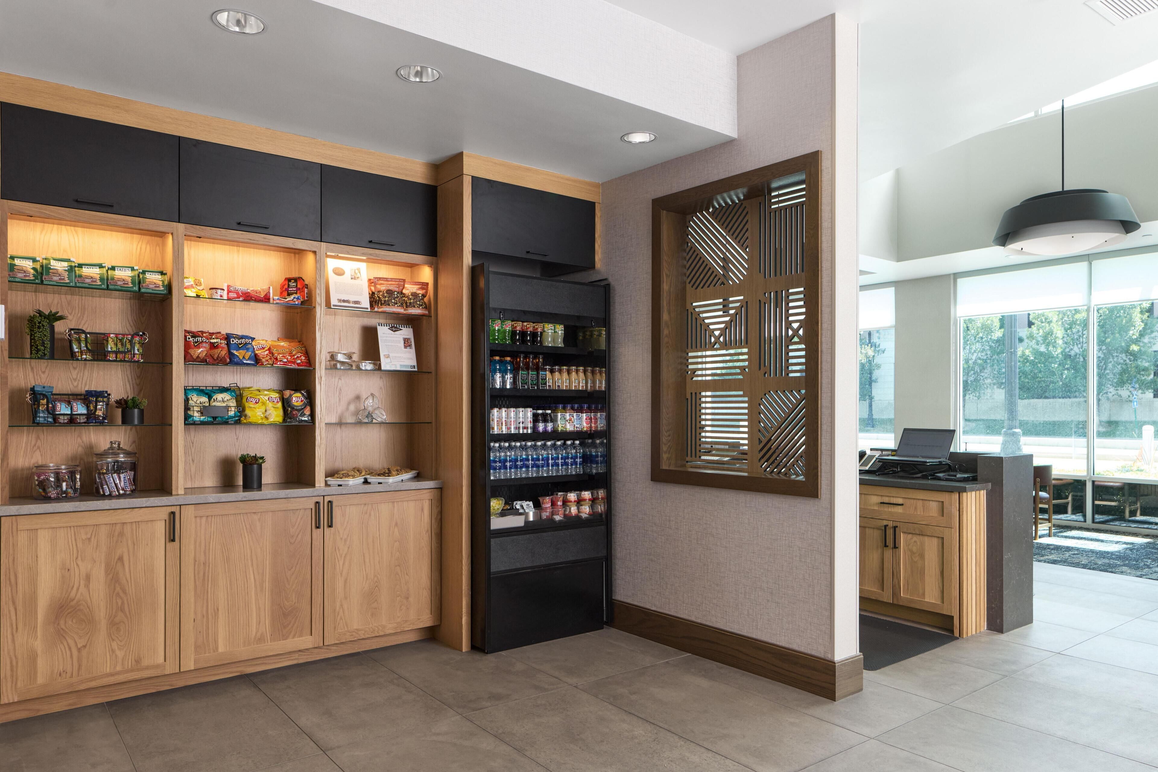 Una cocina moderna con armarios de madera, un refrigerador negro y una ventana con persianas.