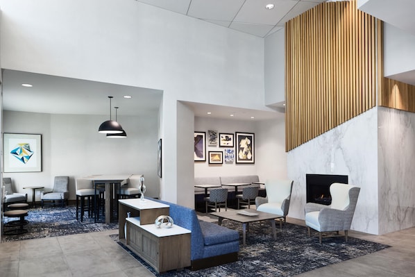 A modern hotel lobby with seating areas, a fireplace, and artwork on the walls. - Hyatt Place Salt Lake City/Downtown/The Gateway (Salt Lake City)