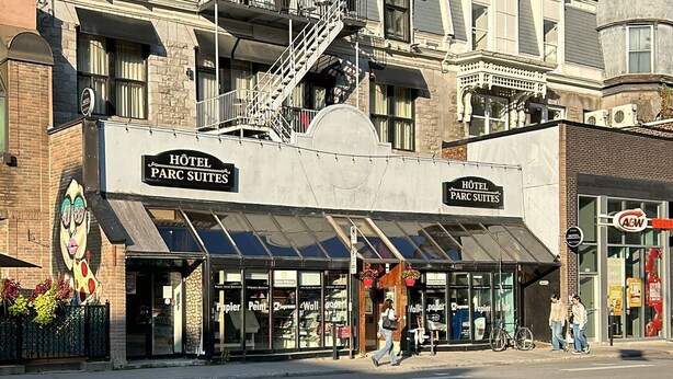 A hotel with a modern facade, multiple floors, and a distinctive tower. - Parc Suites Hotel (Montreal)