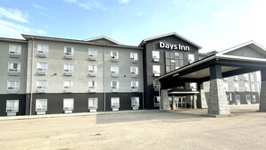 Un hôtel Days Inn au design moderne, doté d’une entrée couverte et de plusieurs étages équipés de climatiseurs.