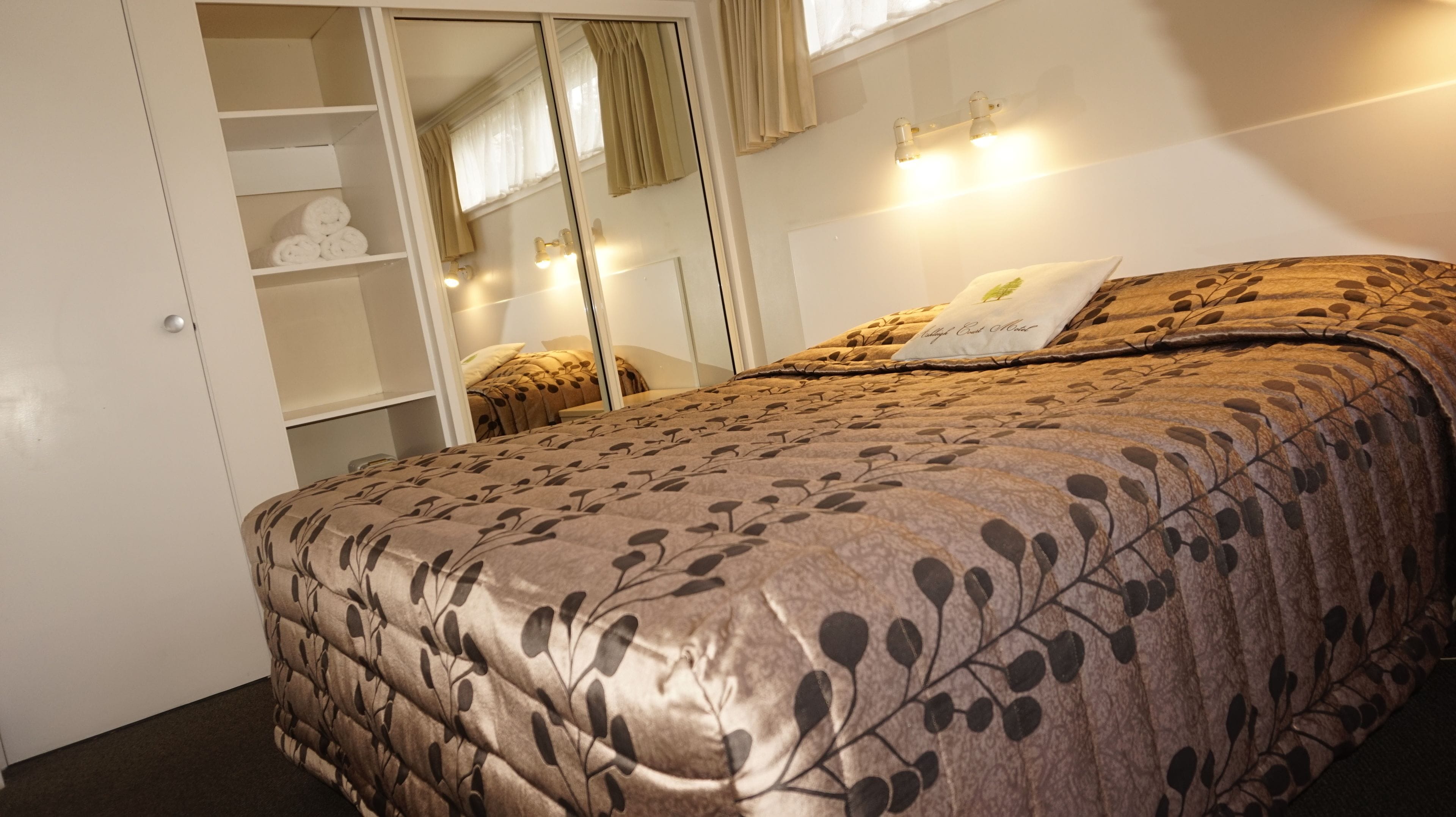 Un dormitorio con cama, armario y espejo.
