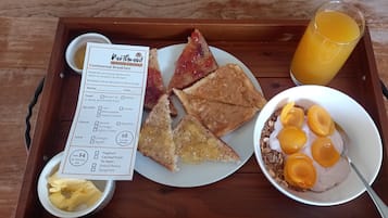 A breakfast tray with toast, a bowl of cereal with fruit, a glass of orange juice, and a menu from Northwood Motor Lodge.