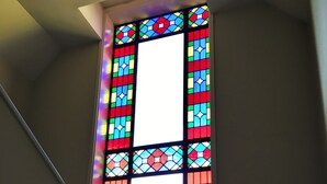 Un vitrail aux motifs géométriques sur fond blanc.
