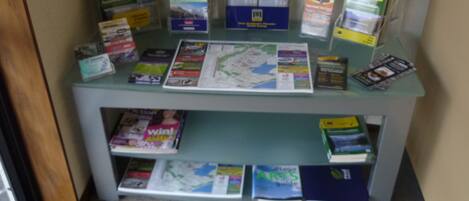 A glass display case with various travel guides and maps.