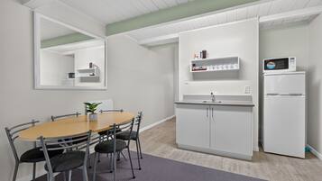 A modern kitchen with white cabinets, a built-in microwave, and a sink.