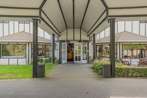 A building entrance with a covered walkway, glass doors, and a reception area. - Capital Lodge Motor Inn (Wellington)