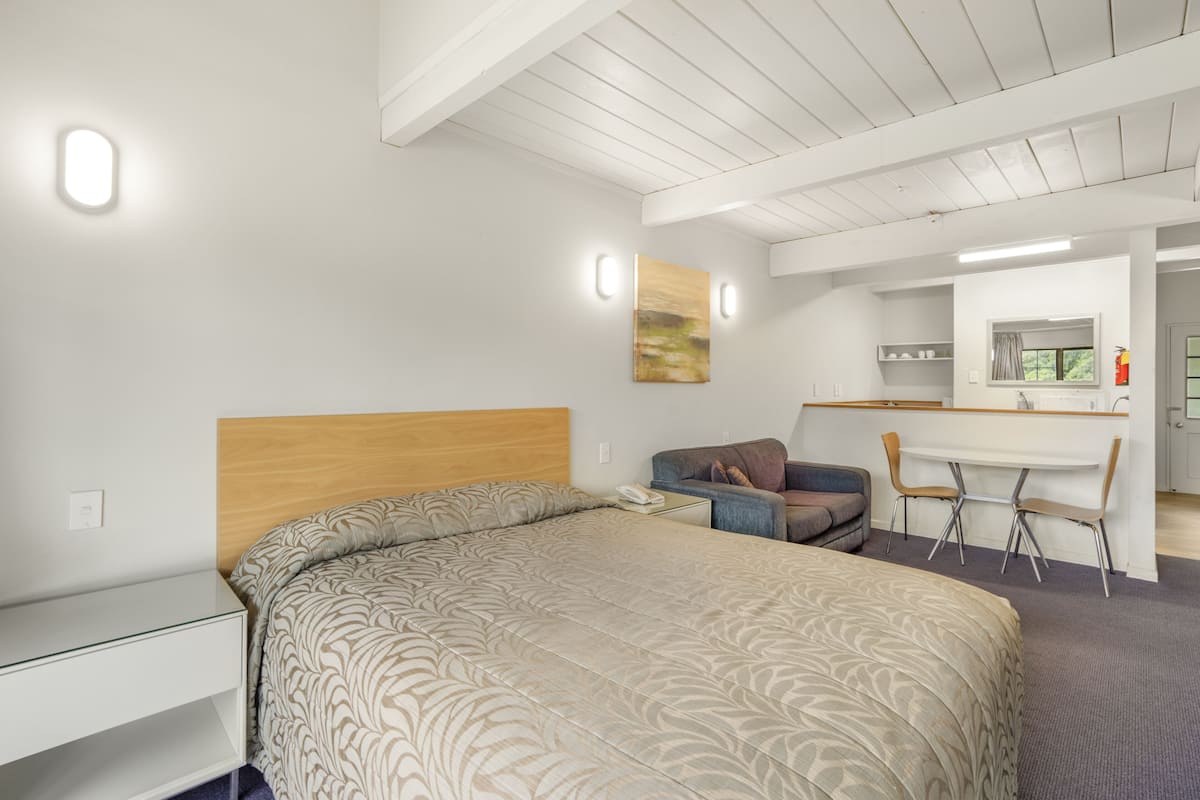 A modern bedroom with a large bed, a desk, and a chair.