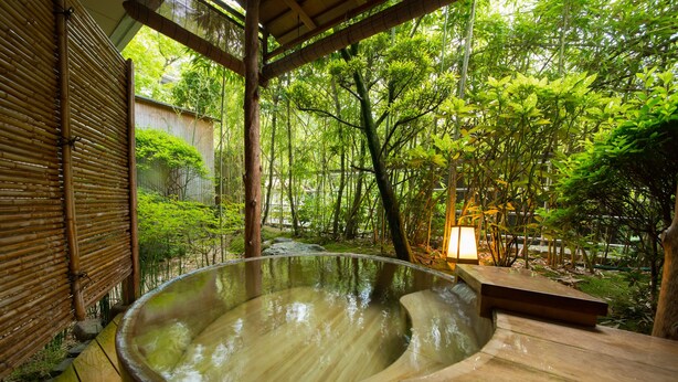 A hot spring bath area with a wooden deck and bamboo structures. - Miyajima Grand Hotel Arimoto (Hatsukaichi)