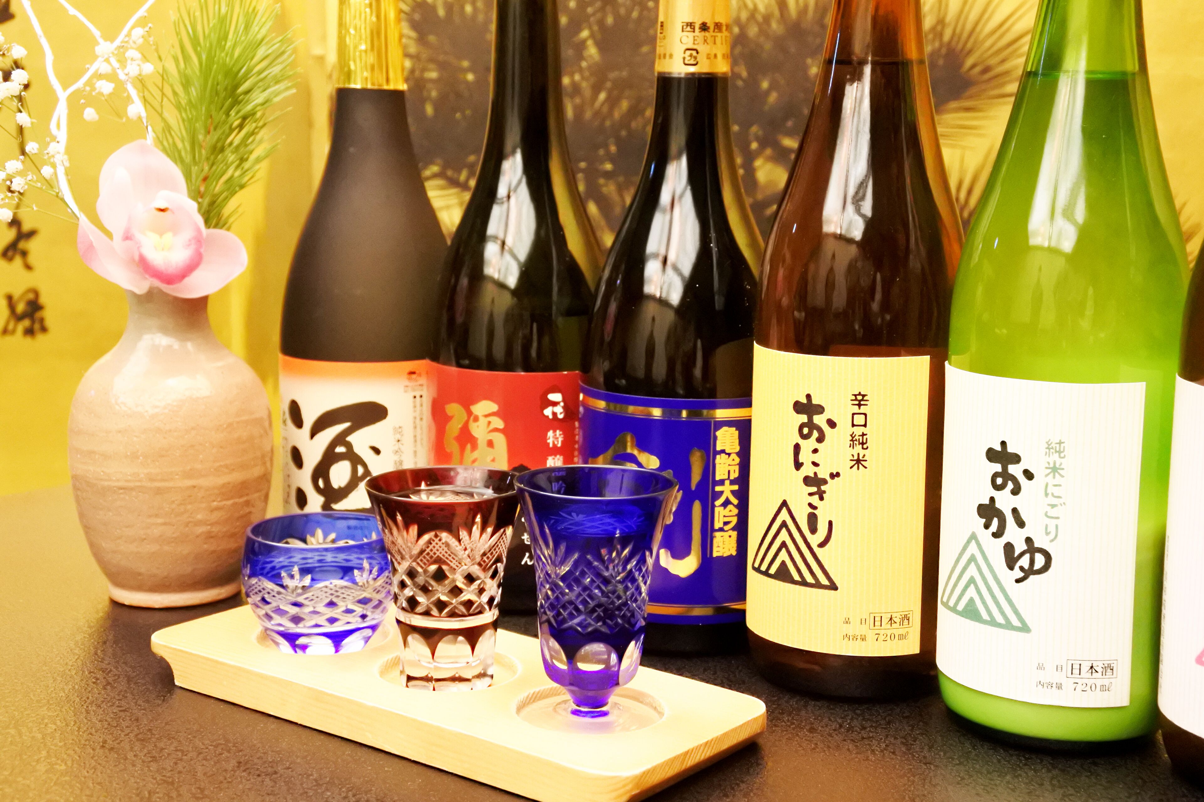 A selection of wine bottles and glasses on a wooden tray.