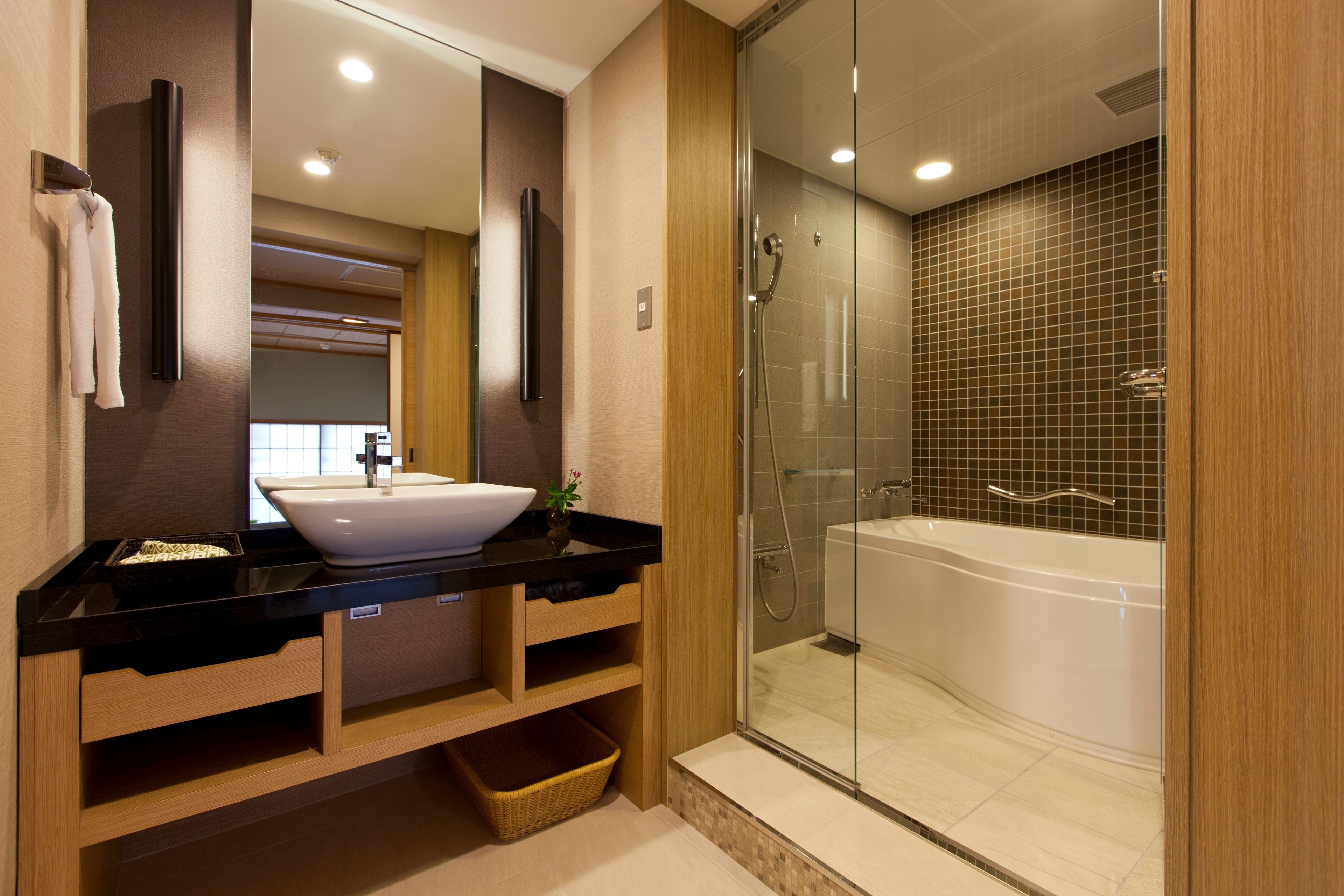 Un baño moderno con un espejo grande, un lavabo, una bañera y una ducha.