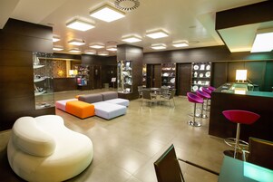 Un moderno vestíbulo de hotel con un área de descanso, una recepción y una exhibición de objetos.