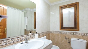 A bathroom with a marble sink, a toilet, and a shower curtain. - Playaolid Suites and Apartments (Adeje)