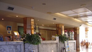 A hotel reception area with marble counters, a PlayaGold sign, and a view of the lobby. - Playaolid Suites and Apartments (Adeje)