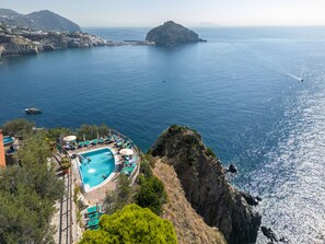 A coastal hotel with a swimming pool, lounge chairs, and a view of the sea. - Punta Chiarito Resort (Forio)