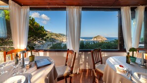 A dining area with a table set for two, overlooking a scenic coastal view. - Punta Chiarito Resort (Forio)