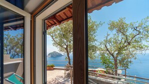 A balcony with a view of the sea and a distant island. - Punta Chiarito Resort (Forio)