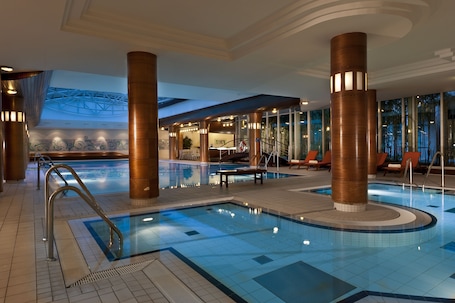 Una piscina techada, sillones reclinables de piscina