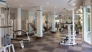 A modern gym with various exercise equipment, large windows, and a clean, spacious layout. - City Hotel Dresden Radebeul (Radebeul)