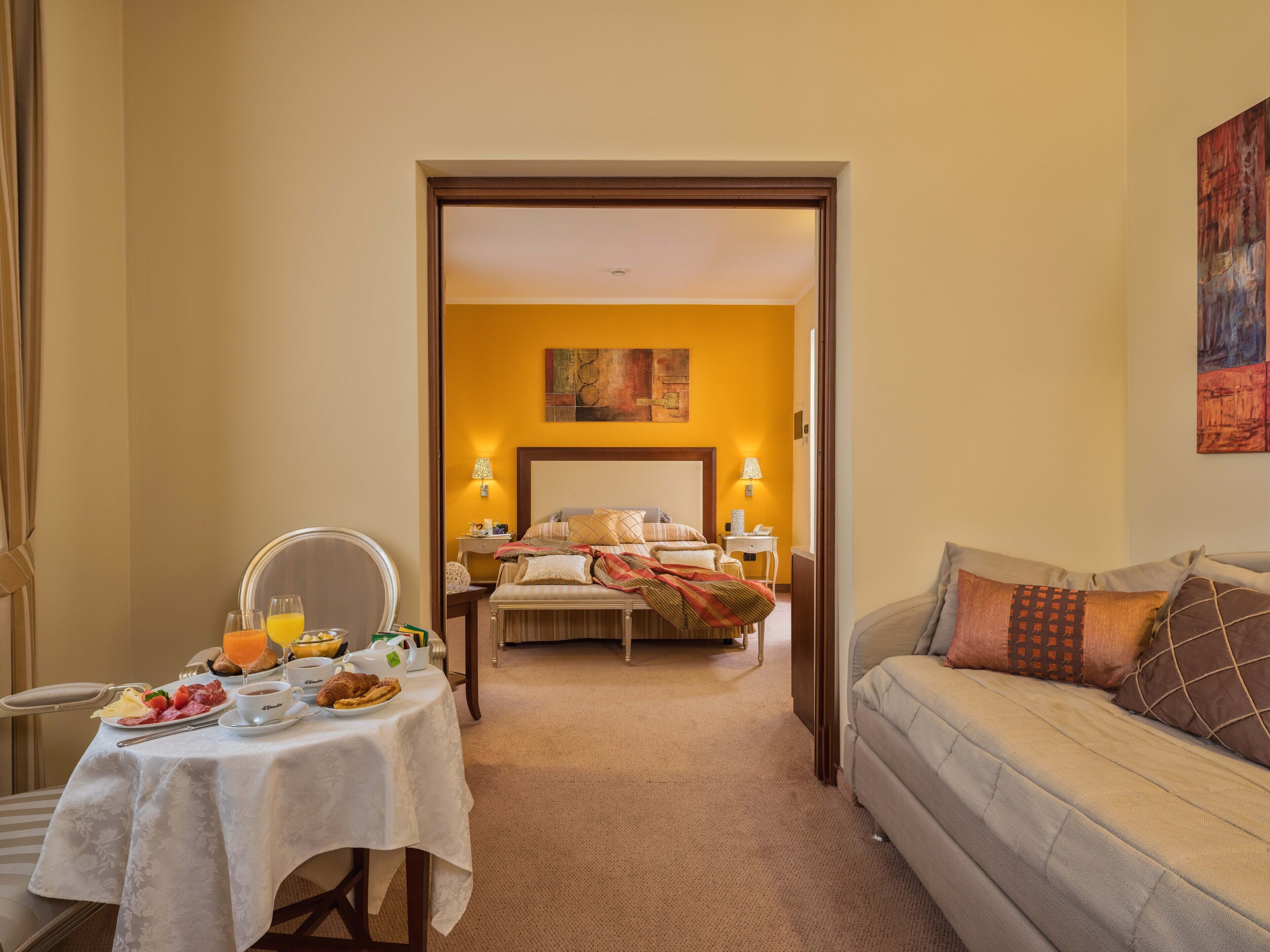 Ein Hotelzimmer mit Essbereich, einem Bett und einer Couch.