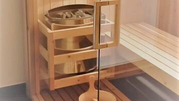 A sauna room with wooden benches and a glass partition.