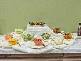 A table with various food items and a bottle of olive oil.