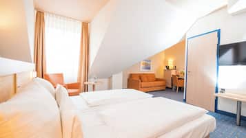 Een hotelkamer met een groot bed, een bureau, een stoel en een televisie.