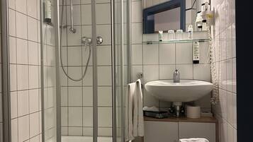 Une salle de bain moderne avec une douche à parois de verre, un lavabo et des toilettes.