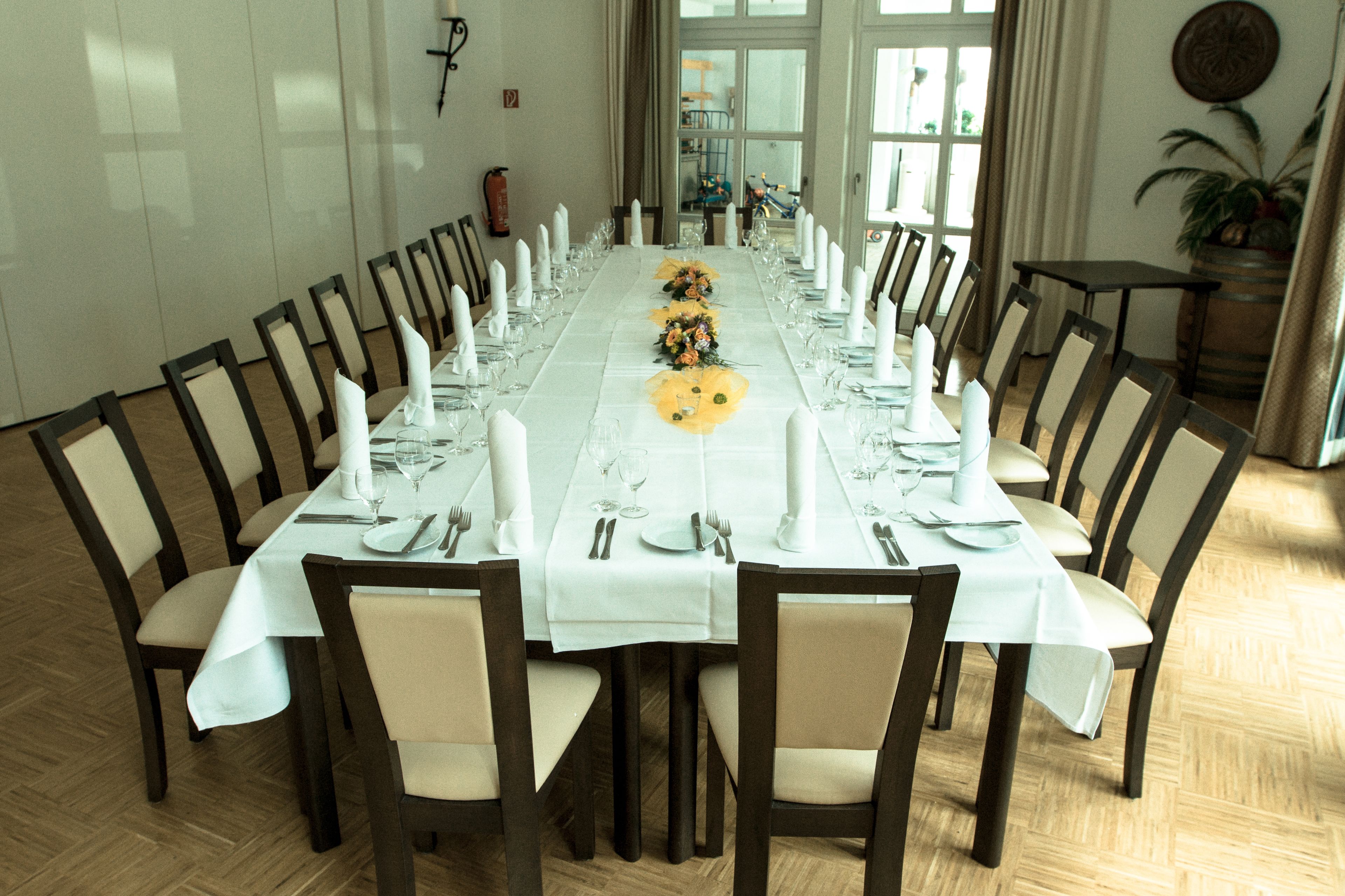 A long dining table set for a formal meal with chairs around it.