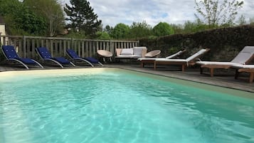 Een buitenzwembad en ligstoelen