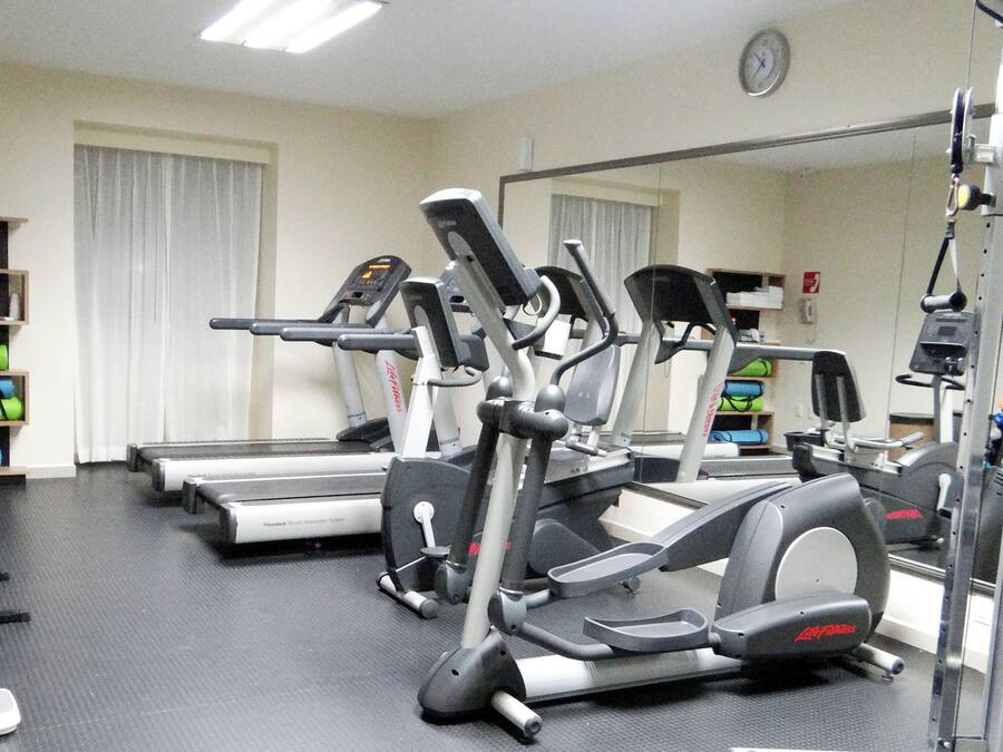 A gym with treadmills, elliptical machines, and weight equipment.