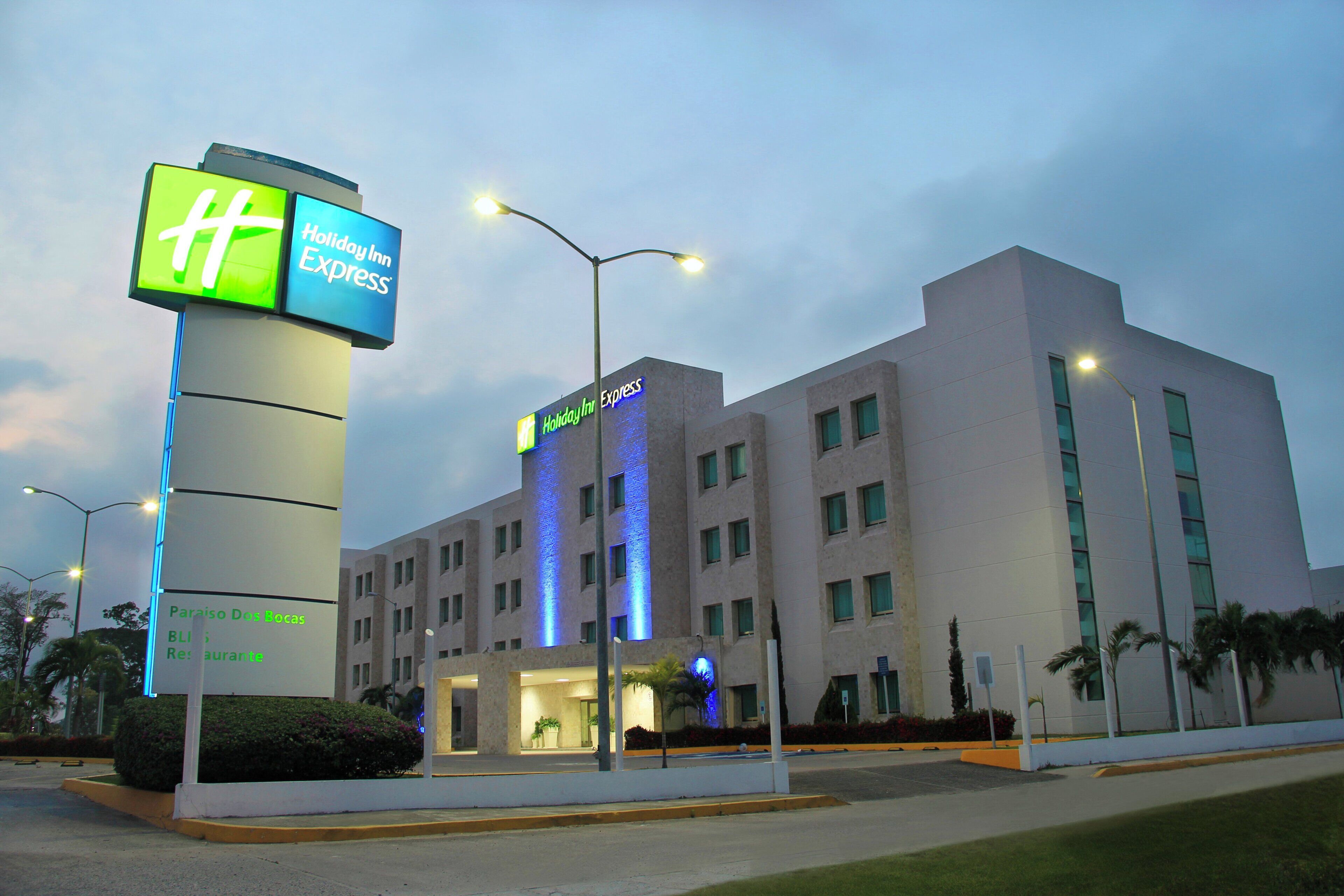 A Holiday Inn Express hotel with a prominent sign, a modern building facade, and a well-lit entrance.