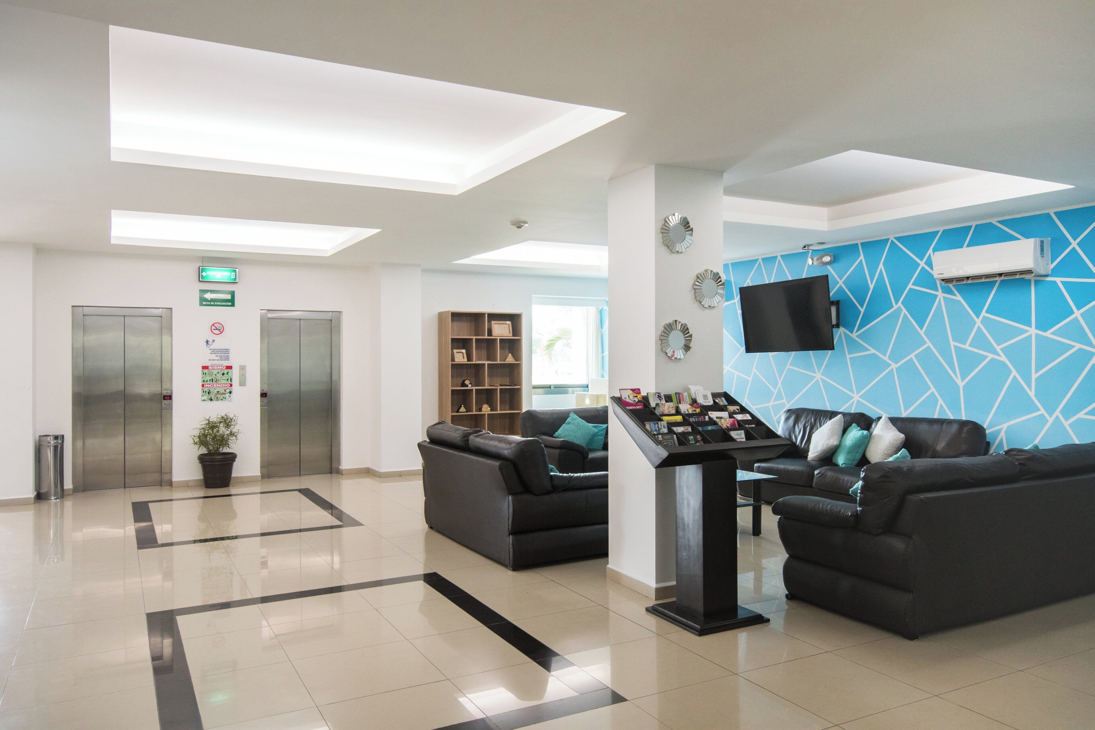 A modern reception area with a reception desk, seating area, and a blue patterned wall.