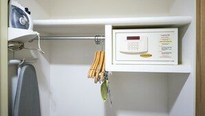 A control panel with a digital display and a welcome message, a hairdryer, and a set of wooden-handled tools hanging on a metal rod.