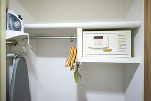 Un panneau de commande doté d’un écran numérique et d’un message d’accueil, un sèche-cheveux et un ensemble d’outils à manche en bois, suspendus à une tige métallique.