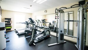 A gym with treadmills, elliptical machines, and weightlifting equipment.